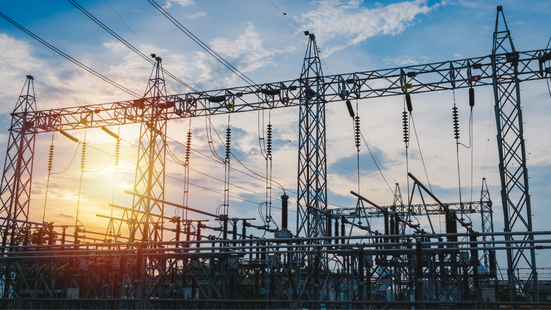 Hoogspanningsstation met elektriciteitskabels tijdens zonsondergang
